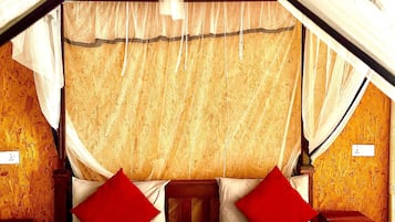 Una cama con dosel, una mesita de noche y un buró.