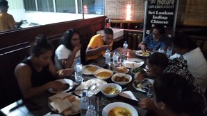 Un grupo de personas cenando en un restaurante que ofrece cocina de Sri Lanka, India y China.