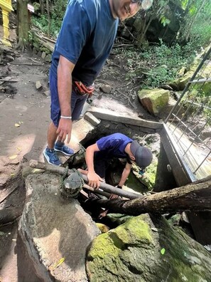 Uma pessoa trabalhando em um canteiro de obras, com ferramentas e uma estrutura em construção.
