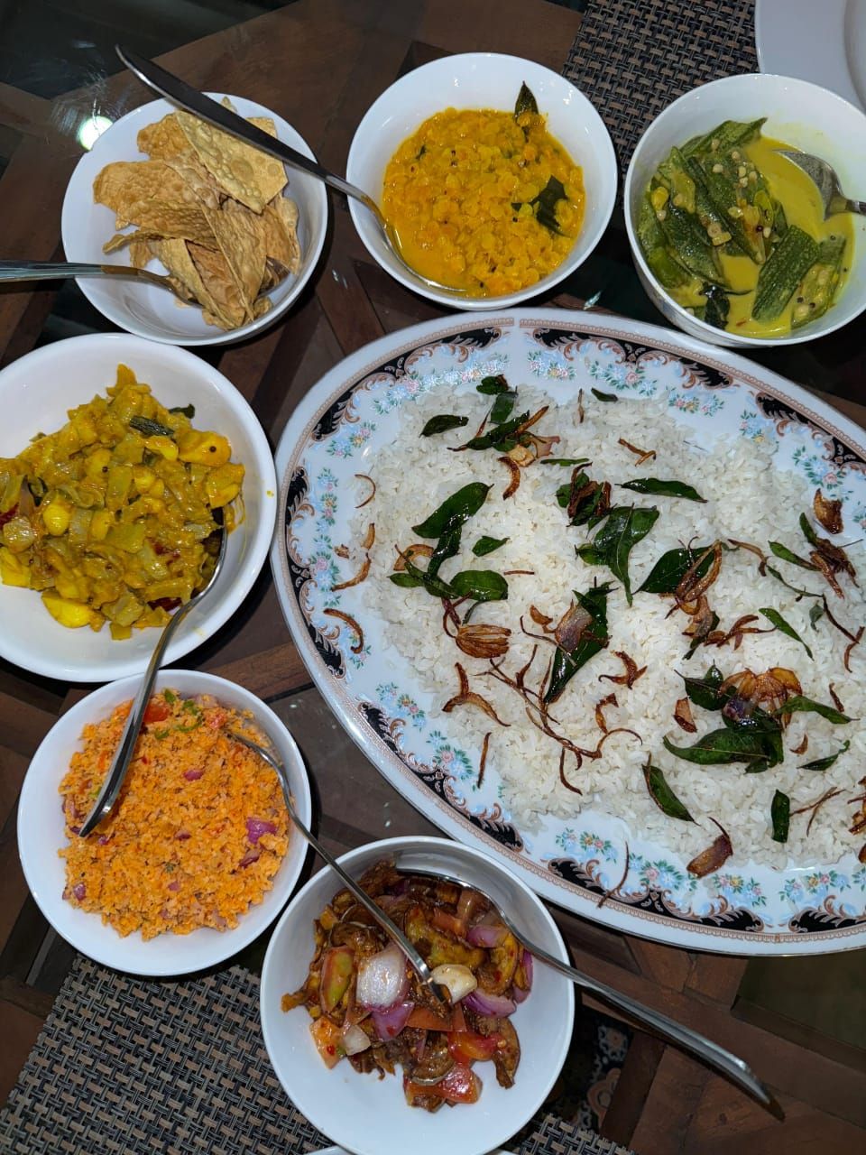 A table with various dishes including rice, curry, and vegetables.