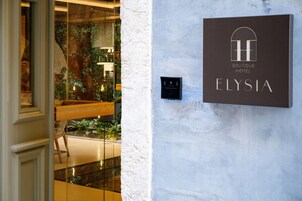 A hotel sign with the name 'Elysia' and a logo indicating it's a boutique hotel.