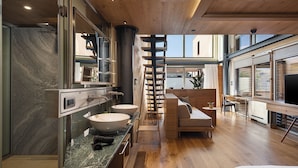 A modern kitchen with a large island, wooden flooring, and a view of the city. - Elysia Boutique Hotel (Chania)
