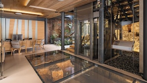 A modern interior with a wooden ceiling, glass walls, and a central atrium with a glass floor. - Elysia Boutique Hotel (Chania)