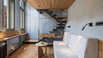 A modern interior with a wooden staircase, a sofa, and a small table.