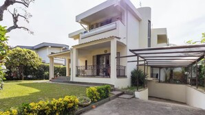 A modern two-story house with a covered patio and a well-maintained garden.