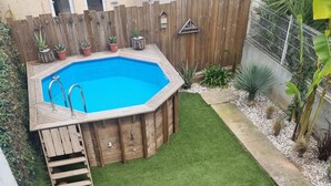 A backyard with a hot tub, a wooden deck, and a brick patio. - Well-decorated family home, 2 steps from the bike path. (Agde)