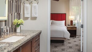 A hotel bathroom with a granite countertop, a sink, and a vase with flowers. - Adventure Awaits at Marriott Desert Springs II - Luxury and Fun in the Dessert (Palm Desert)