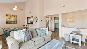 A living room with a sofa, coffee table, and a dining area with chairs and a table. - Close to Beach ~ Family Friendly ~ Ocean Views from Second Floor ~ Dog Friendly (Fernandina Beach)