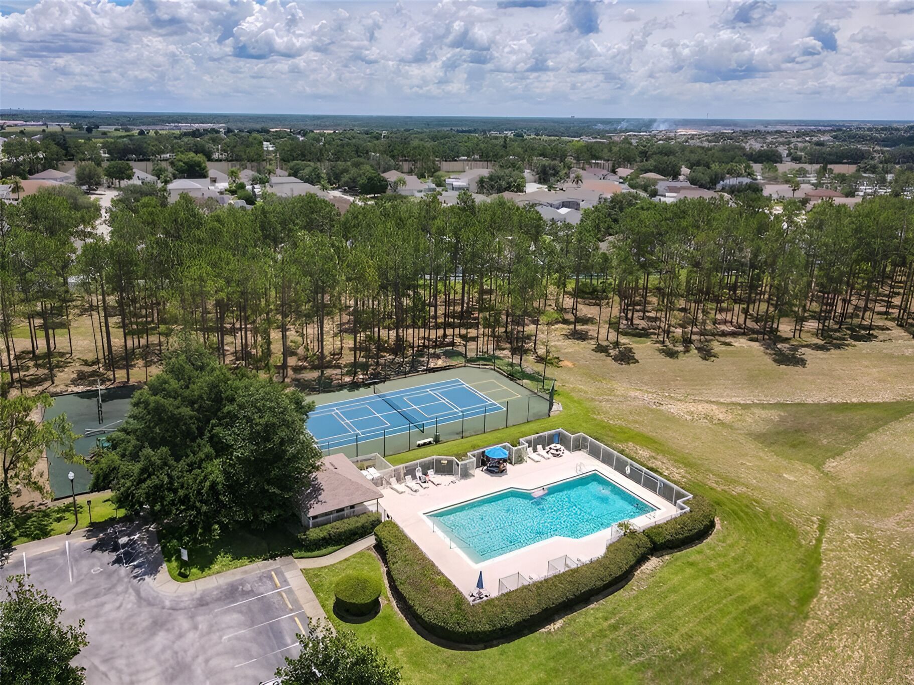 Uma área residencial com quadra de tênis, piscina e estacionamento.