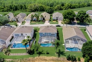 A residential area with multiple houses, each featuring a swimming pool and a covered patio area.