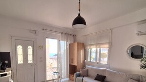 Una sala de estar moderna con sofá, mesa de centro y comedor con mesa y sillas.