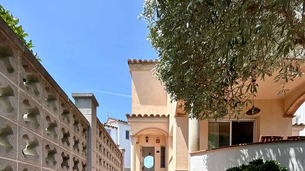 A staircase leading to a building with a tiled roof and a tree providing shade. - Villa Rosell (L'Escala)