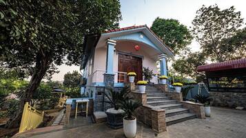 A building with a blue and white facade, a red door, and a staircase leading to the entrance.