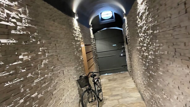 A narrow, brick-walled tunnel with a bicycle parked against the wall. - Welcome to Le Trois Six Very nice air-conditioned duplex (Pézenas)
