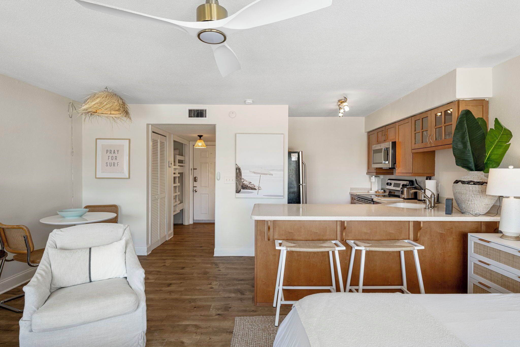 A compact kitchen with a central island, wooden cabinets, and a microwave.