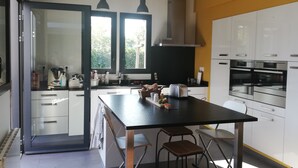 Eine moderne Küche mit schwarzem Arbeitsplatz, Edelstahlgeräten und einem großen Fenster.