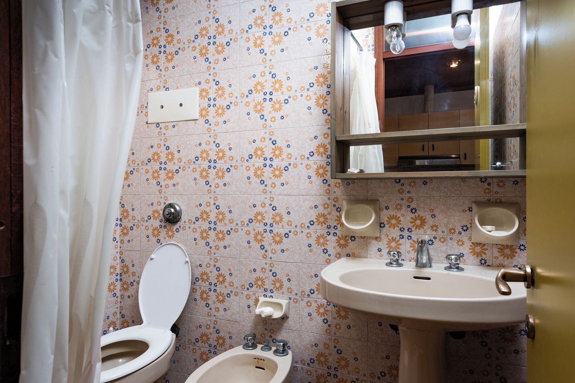 Un baño con inodoro, bidé y lavamanos.