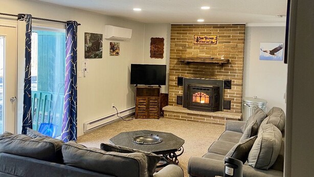 A living room with a fireplace, a television, and a sofa. - Charming 3-bedroom house with WiFi, AC in serene Towamensing Trails (Towamensing Trails)