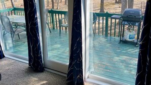 A room with a large sliding glass door leading to an outdoor deck with a grill and chairs. - Charming 3-bedroom house with WiFi, AC in serene Towamensing Trails (Towamensing Trails)