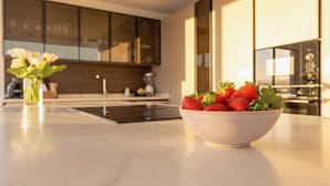 Una cocina moderna con un bol de fresas sobre la encimera.