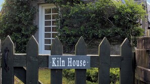 Una puerta de madera con un letrero que dice "Kiln House".