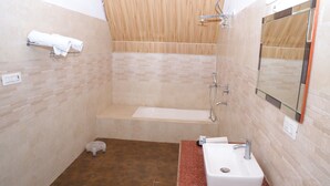 A bathroom with a bathtub, a sink, and a mirror. - BLESSINGS RESORT (Rajgarhi)