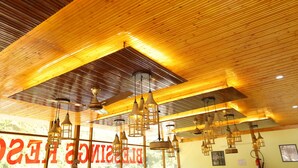 A room with wooden ceiling beams and pendant lights. - BLESSINGS RESORT (Rajgarhi)