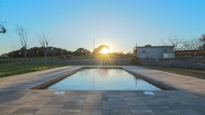 A rectangular pool with a paved deck, surrounded by a low stone wall and a grassy area. - Can Feu: Casa rural, 16-18 personas en Sant Antoni de Vilamajor, 30' Barcelona (Sant Antoni de Vilamajor)