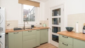 A compact kitchen with a window, a sink, and a wooden countertop. - Charming Family House in Rosewell - Pass the Keys (Edinburgh)