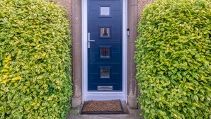 A blue door with a white frame, flanked by two well-trimmed hedges. - Charming Family House in Rosewell - Pass the Keys (Edinburgh)