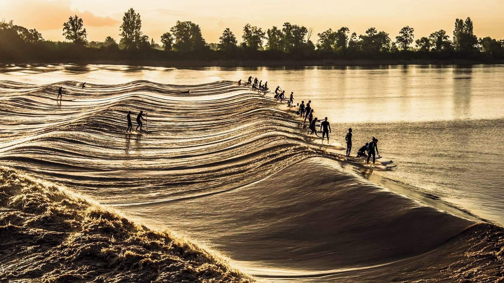 A beach with people surfing and walking along the shore.