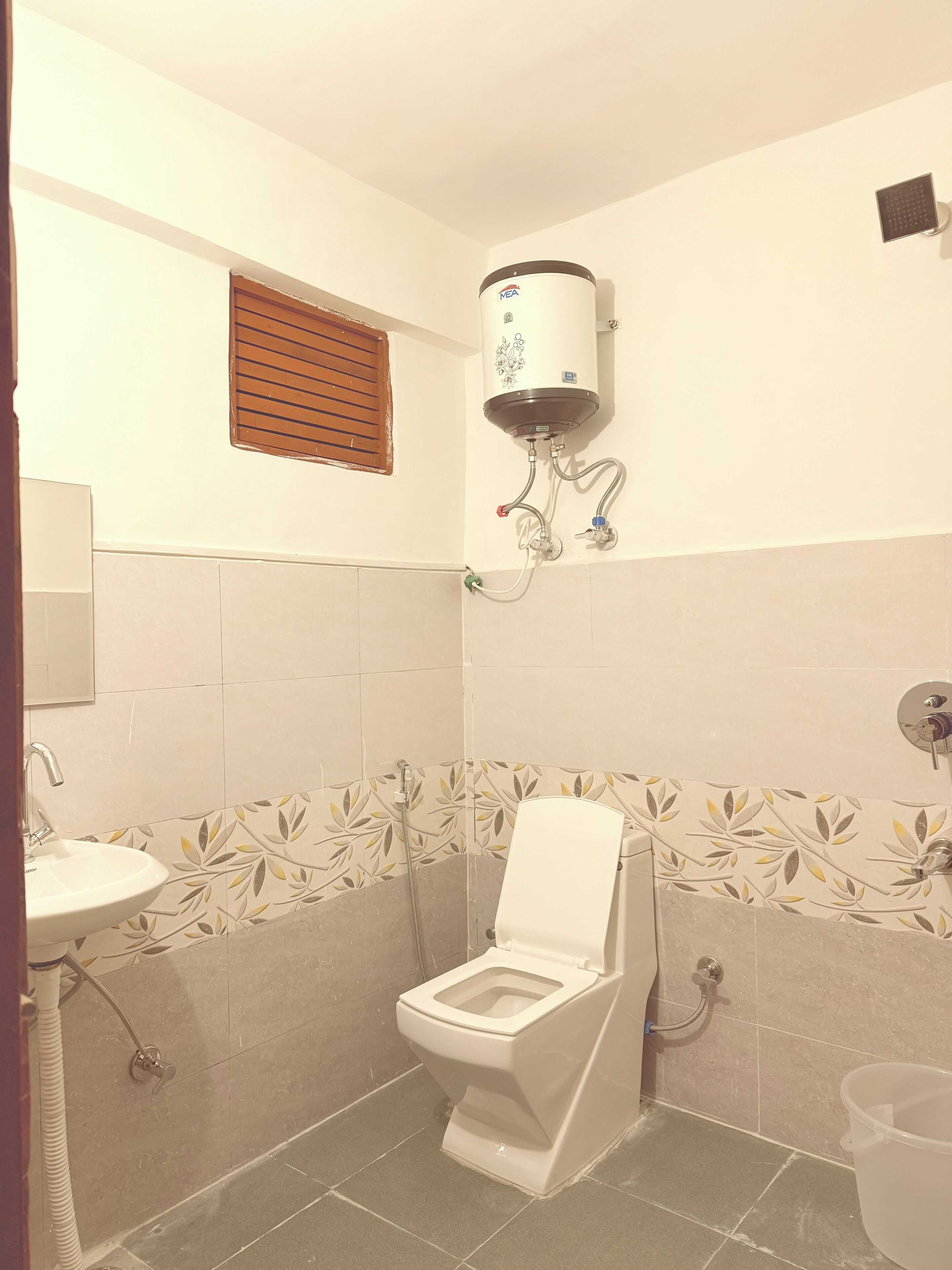 Ein Badezimmer mit Toilette, Waschbecken, Dusche und Wandheizung.