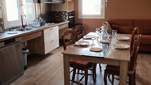 Een moderne keuken met een eetgedeelte, houten vloeren en een groot raam dat voor natuurlijk licht zorgt.