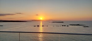 A sunset over a calm sea with distant landforms and a clear sky. -  EdgeWater Beach Hotel (Chania)