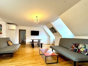 Suite Deluxe, vista città | Area soggiorno | TV a schermo piatto 46 pollici con canali via cavo, TV