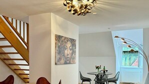 A modern living room with a staircase, a dining area, and a sofa. - Carillon by BestChoice  - Parking Option (Graz)