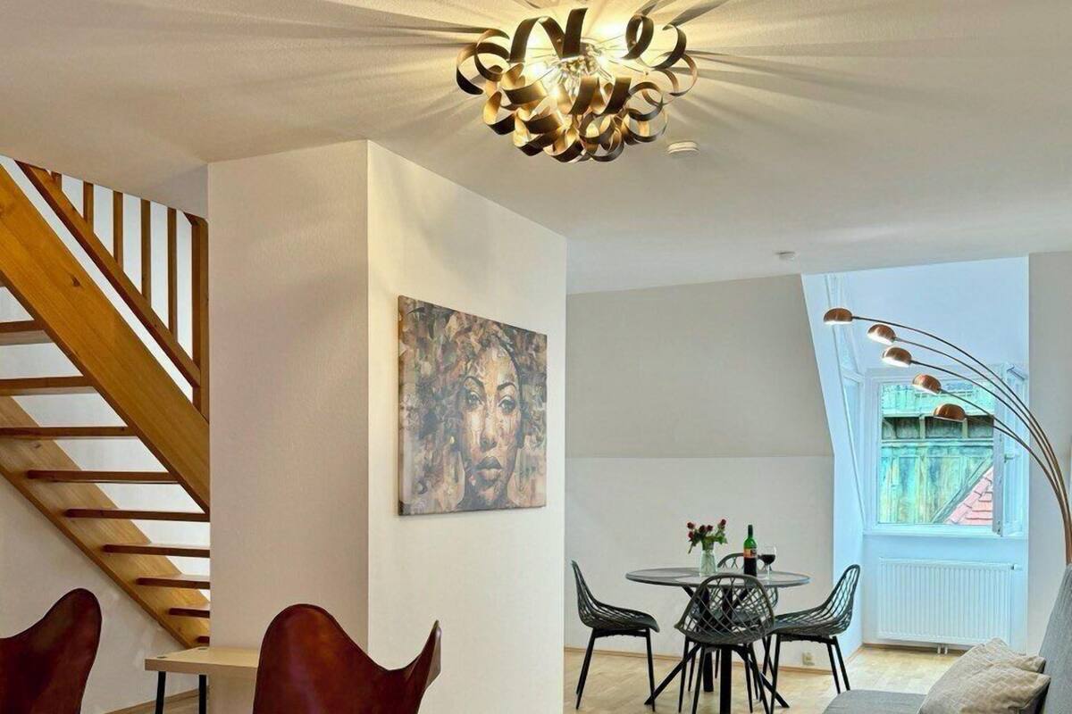 Una sala de estar moderna con una escalera, un comedor y un sofá.