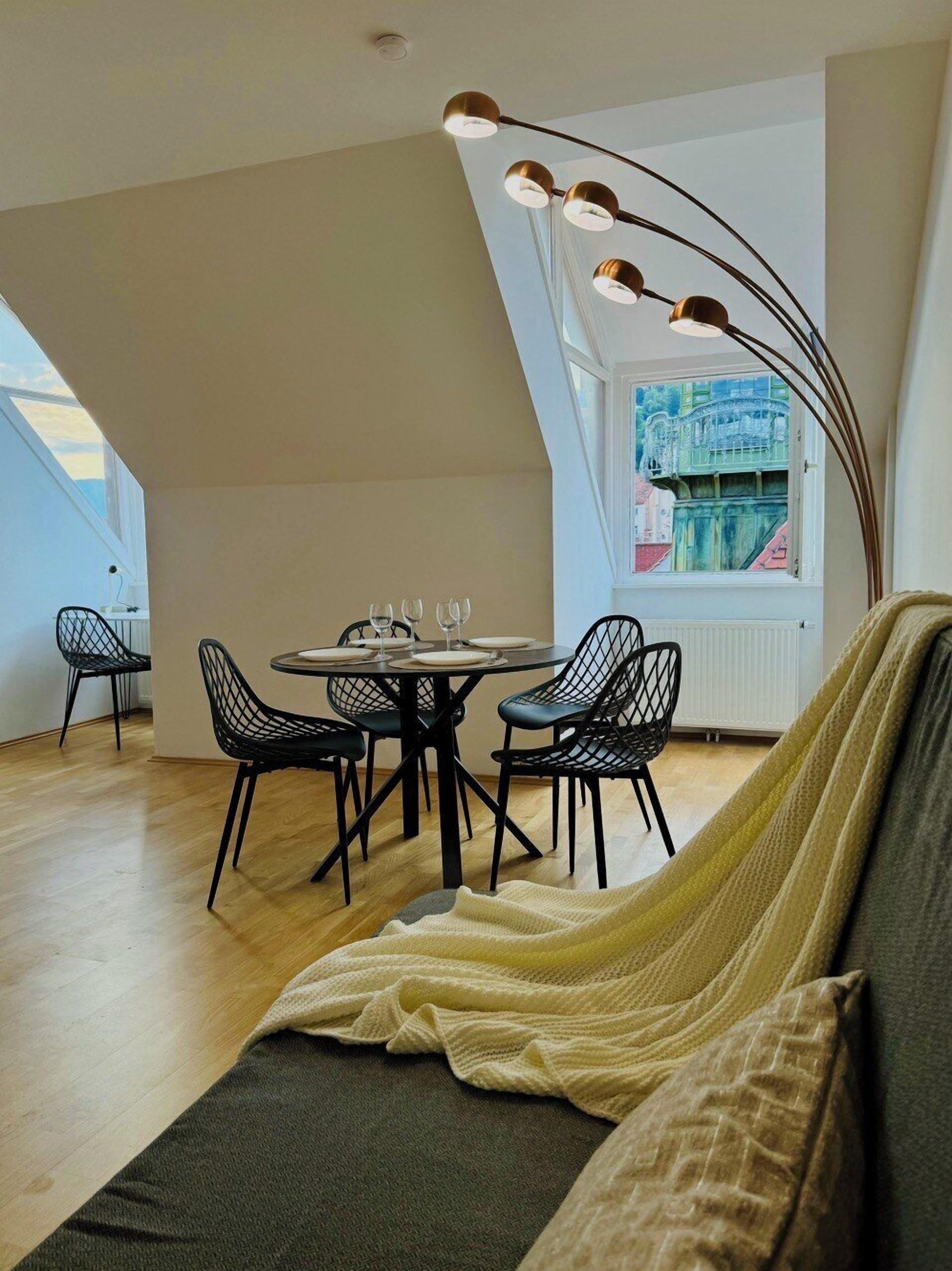 Une chambre de style loft moderne, dotée d’un espace repas, d’une grande fenêtre offrant une vue imprenable et d’un luminaire au design original, avec un plafond incurvé.