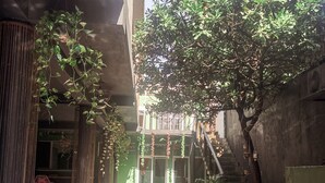 A courtyard with a staircase, potted plants, and a wooden bench. - Varuna Home (Tulum)