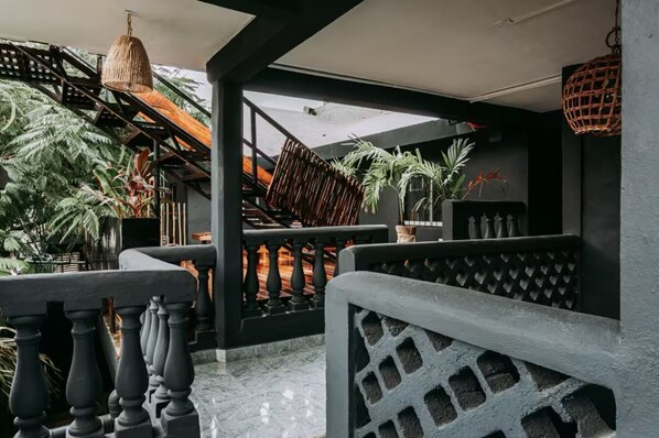 A modern outdoor area with a staircase, black railings, and various plants. - Varuna Home (Tulum)