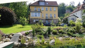A residential property with a swimming pool, a wooden deck, and a well-maintained garden. - Pension Villa am Burgberg (Waltershausen)