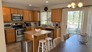 A modern kitchen with wooden cabinets, stainless steel appliances, and a central island with stools. - 4-bed 2.5 bathroom in North Spokane with treadmill, WiFi, AC (Spokane)