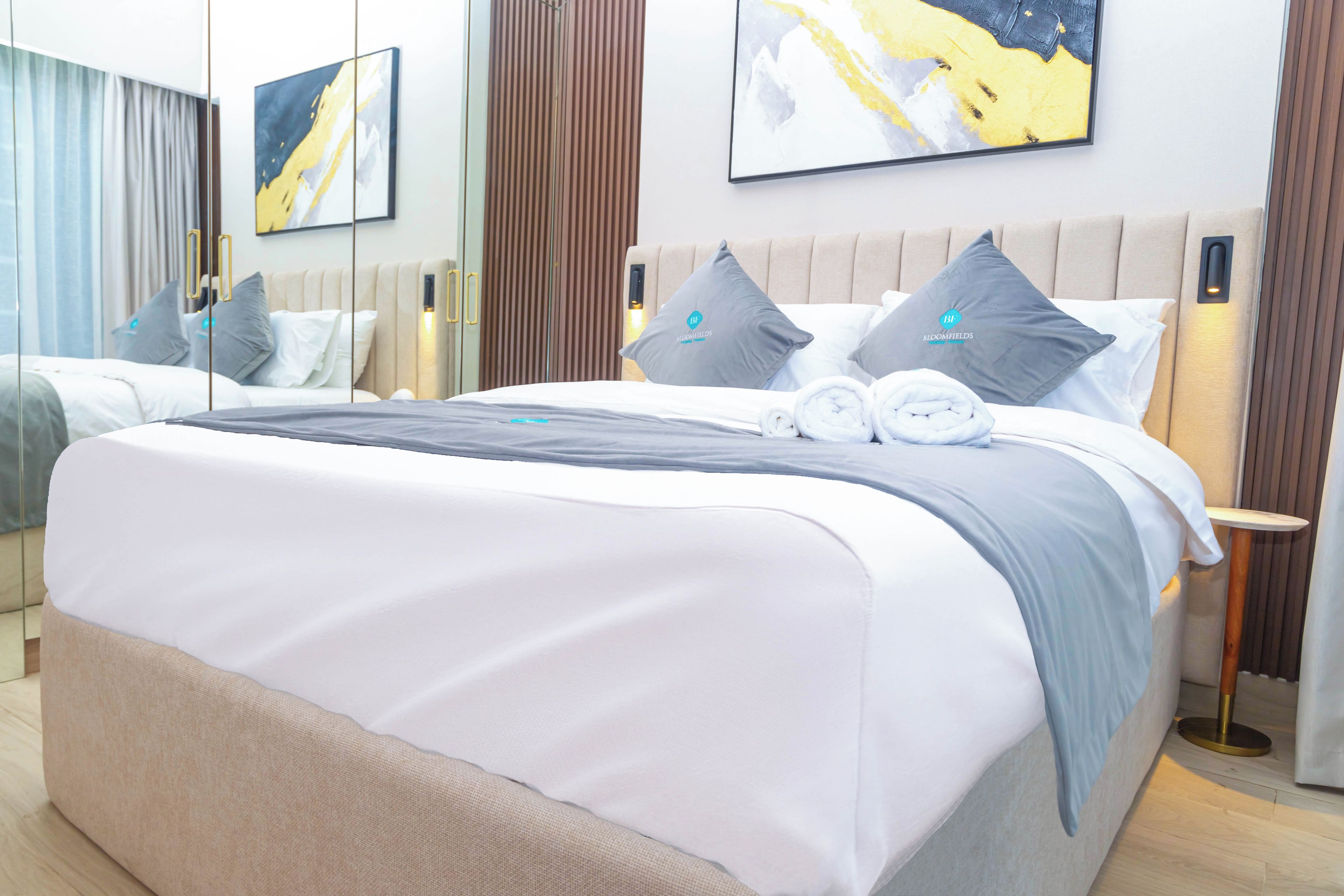 Una habitación de hotel con una cama grande, una mesita de noche y una mesilla.