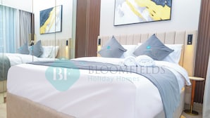 A hotel room with a large bed, a bedside table, and a wall-mounted light.