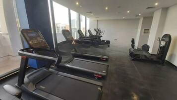 Ein Fitnessstudio mit Laufbändern und Ergometer, großen Fenstern und modernem Design.
