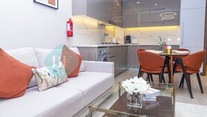 A modern living room with a sofa, coffee table, and dining area with chairs.