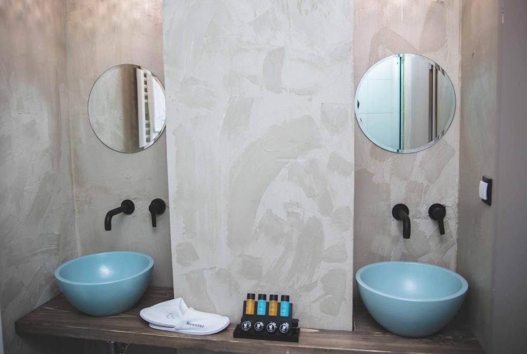 A bathroom with two blue sinks, a white towel, and a soap dispenser set.