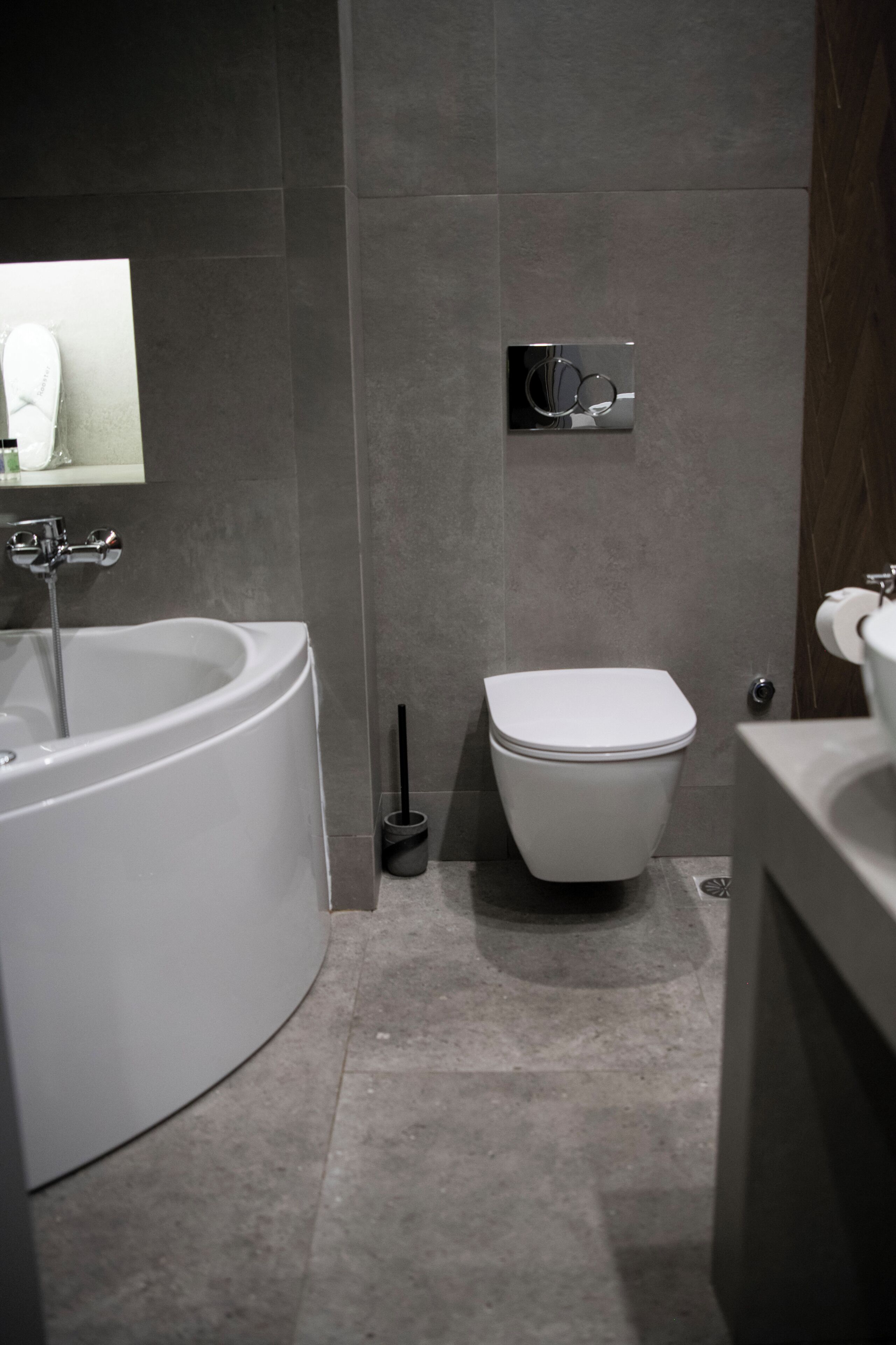 A modern bathroom with a bathtub, toilet, and sink.