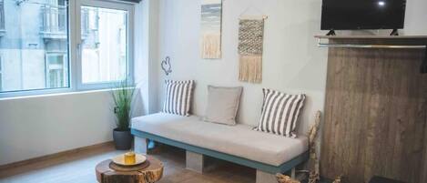 A modern living room with a sofa, a television, and a wooden coffee table.