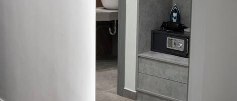 Un baño moderno con un lavamanos blanco, un perchero y una zona de ducha.